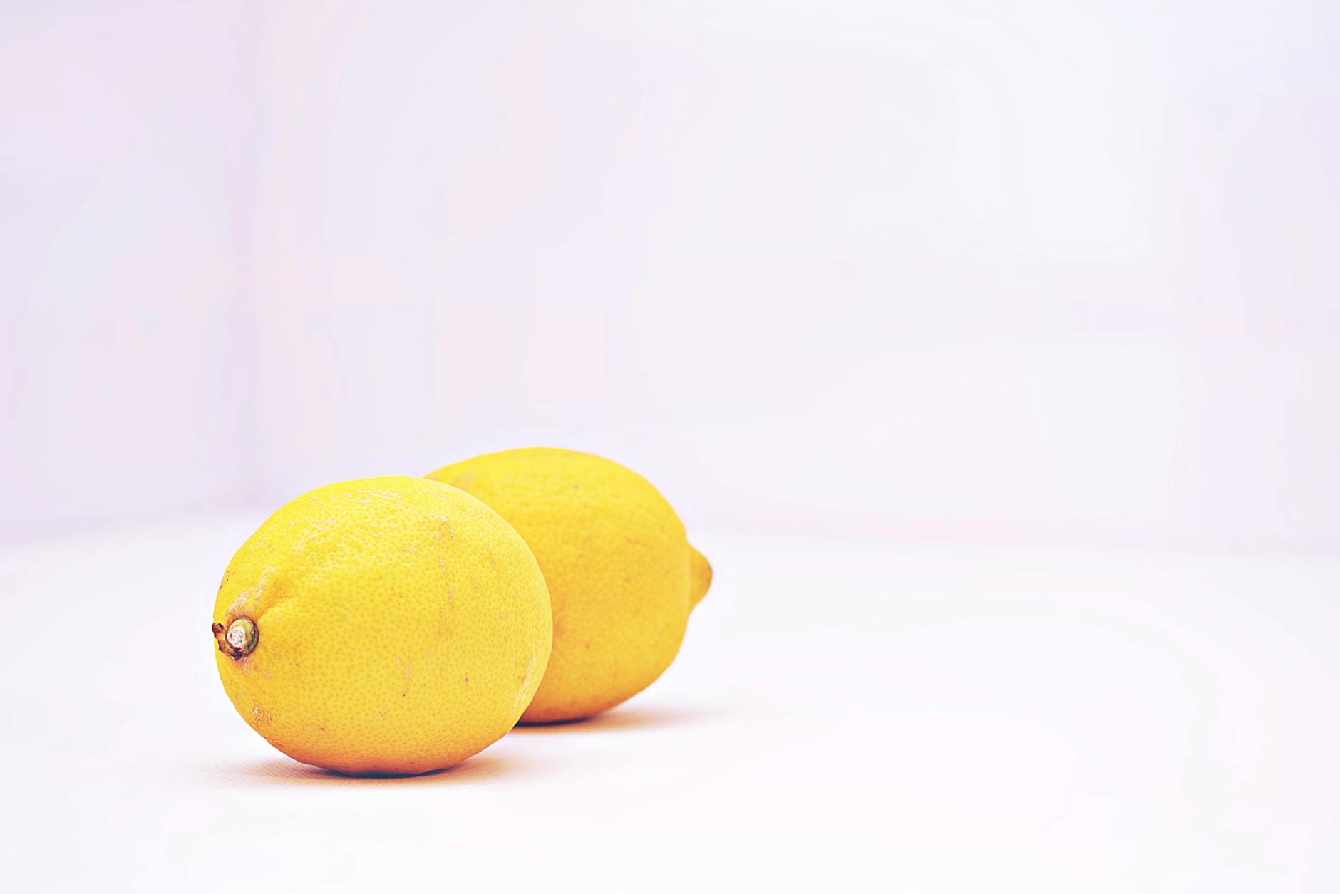 Two vibrant lemons side by side on a white background representing lemon vibrators and alternative options