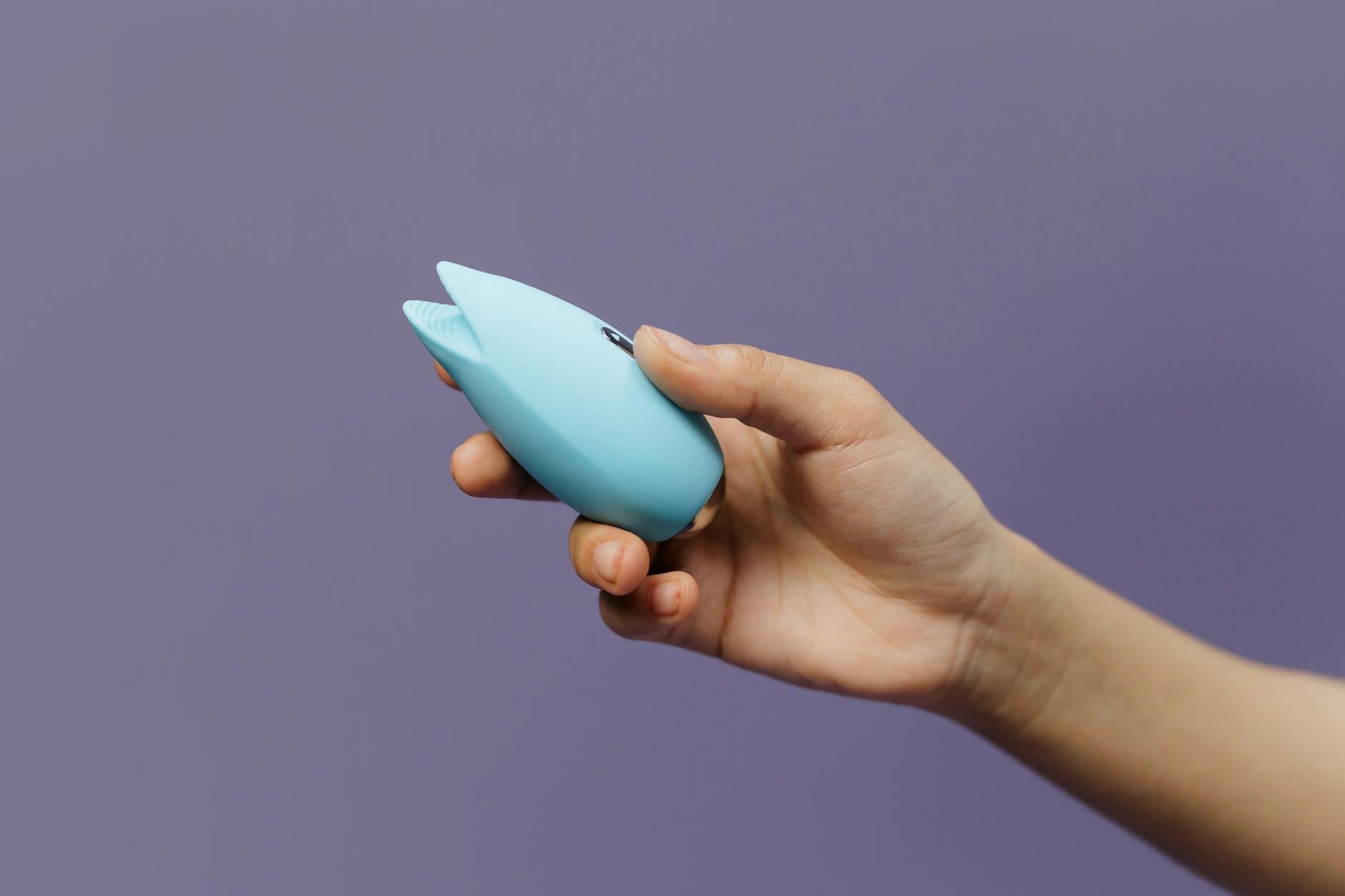 A blue silicone sex toy held in hand, symbolizing self-pleasure and returning to sexual wellness