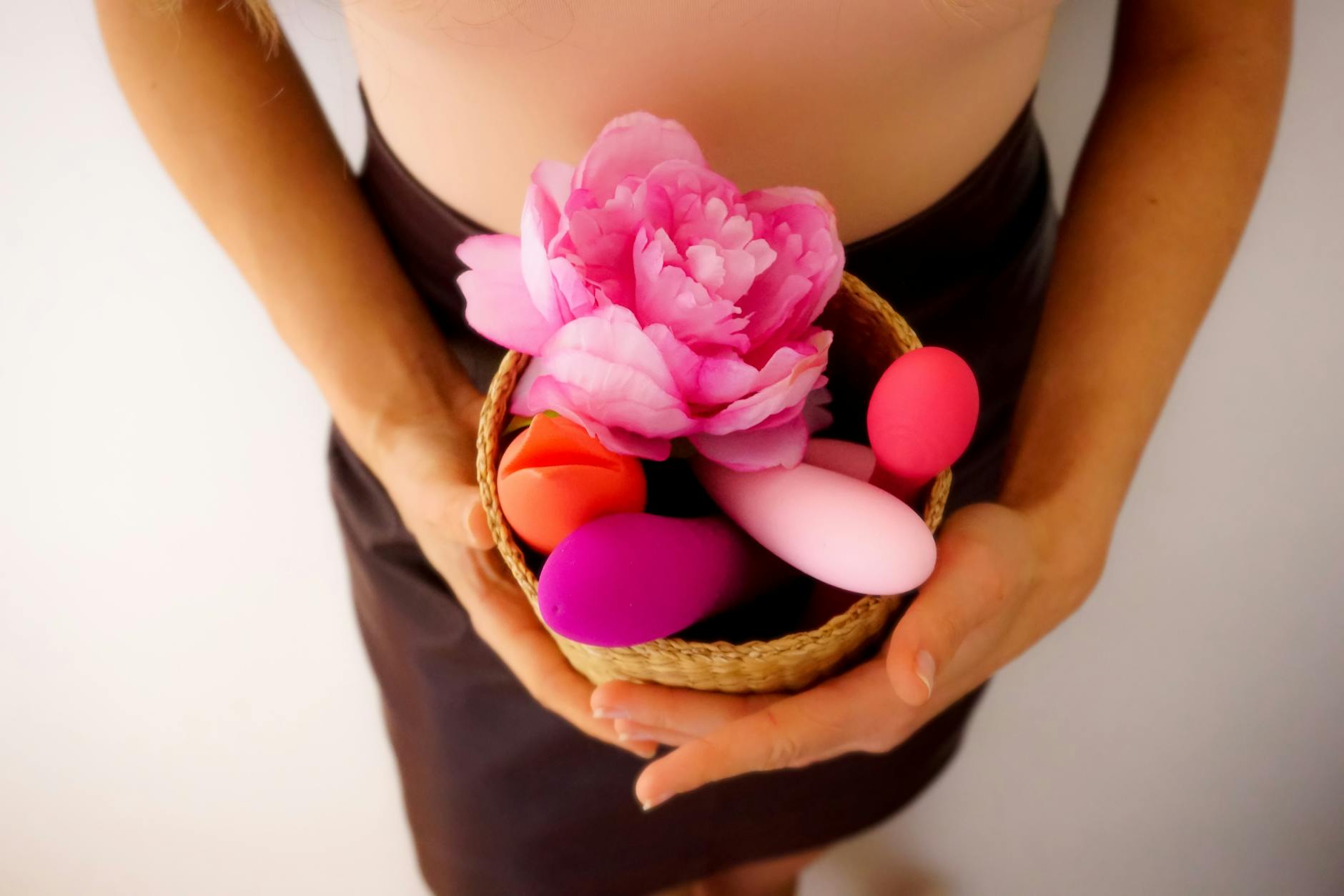 A collection of colorful vibrators and wellness products in a basket, showing different toy options.
