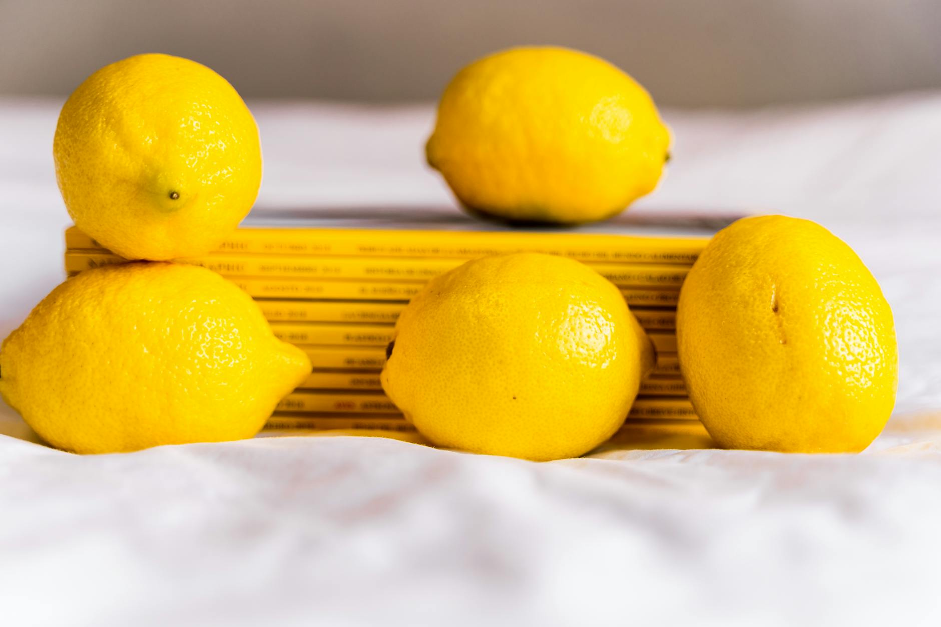 Hand holding a fresh lemon on soft pink background, symbolizing reconnection and renewal